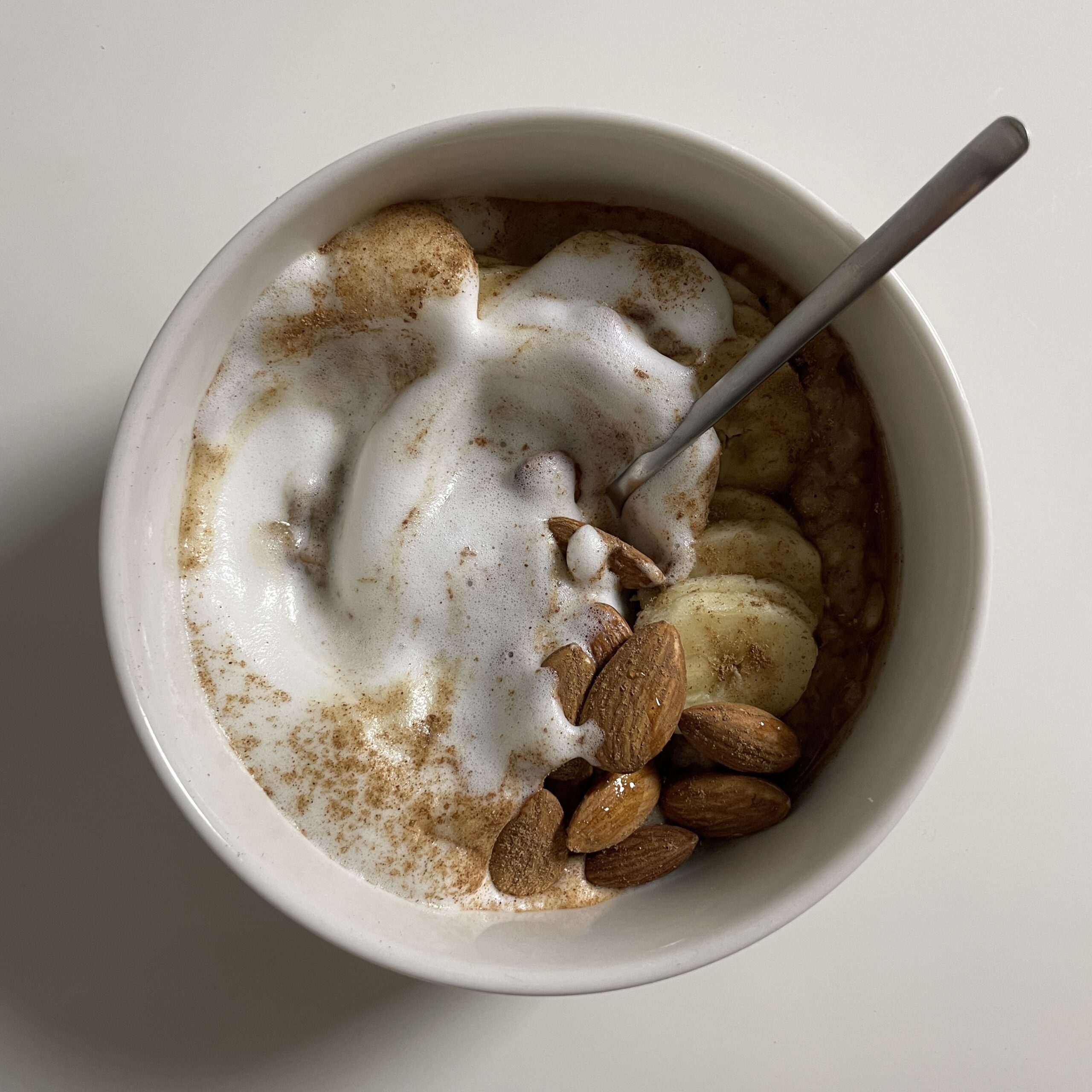 Creamy Cinnamon Oatmeal with Frothed Milk, Banana and Almonds